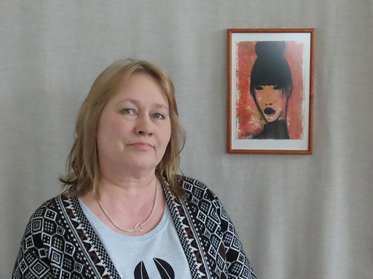 Artist Helena Junttila next to a painting of a woman