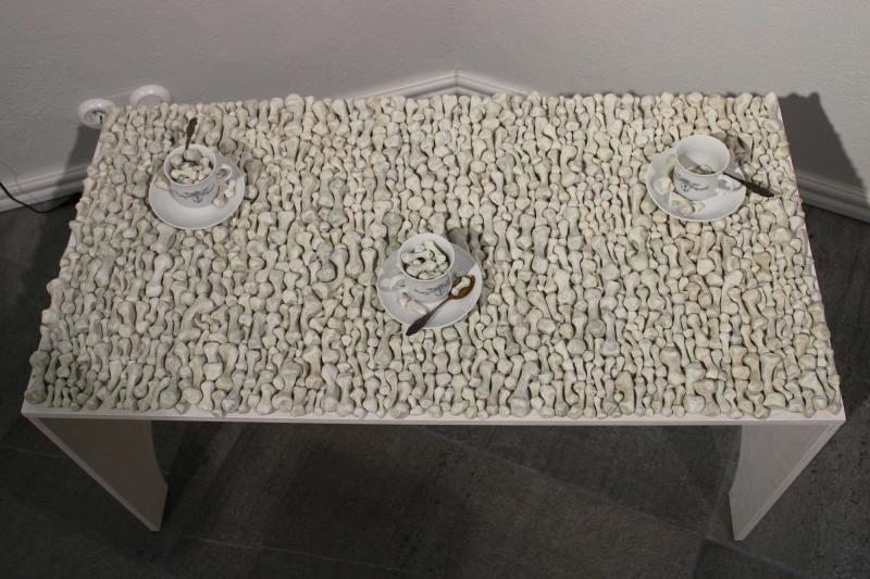 Tiina Seppälä, Viimeiset vieraat, Darwi-massa, akvarelliväri, posliiniastiat, lusikat ja vaneri, 100x60x50cm, 2024,  kuvaaja Tiina Seppälä