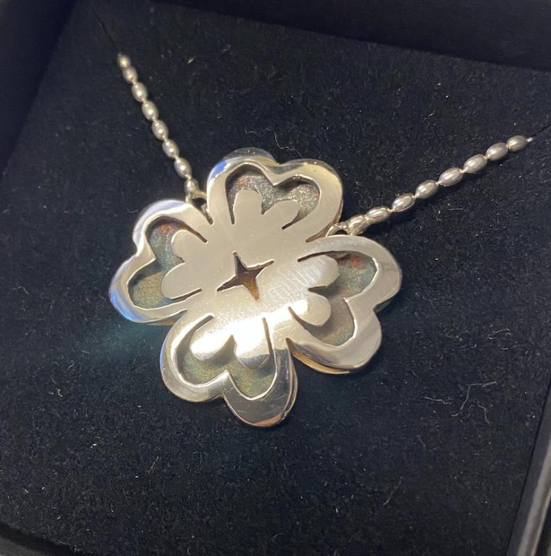 “Vänskap” En blomma formad av fyra hjärtan. 2023. Ca 20x20 mm. Sågat ur silverplåt 925.